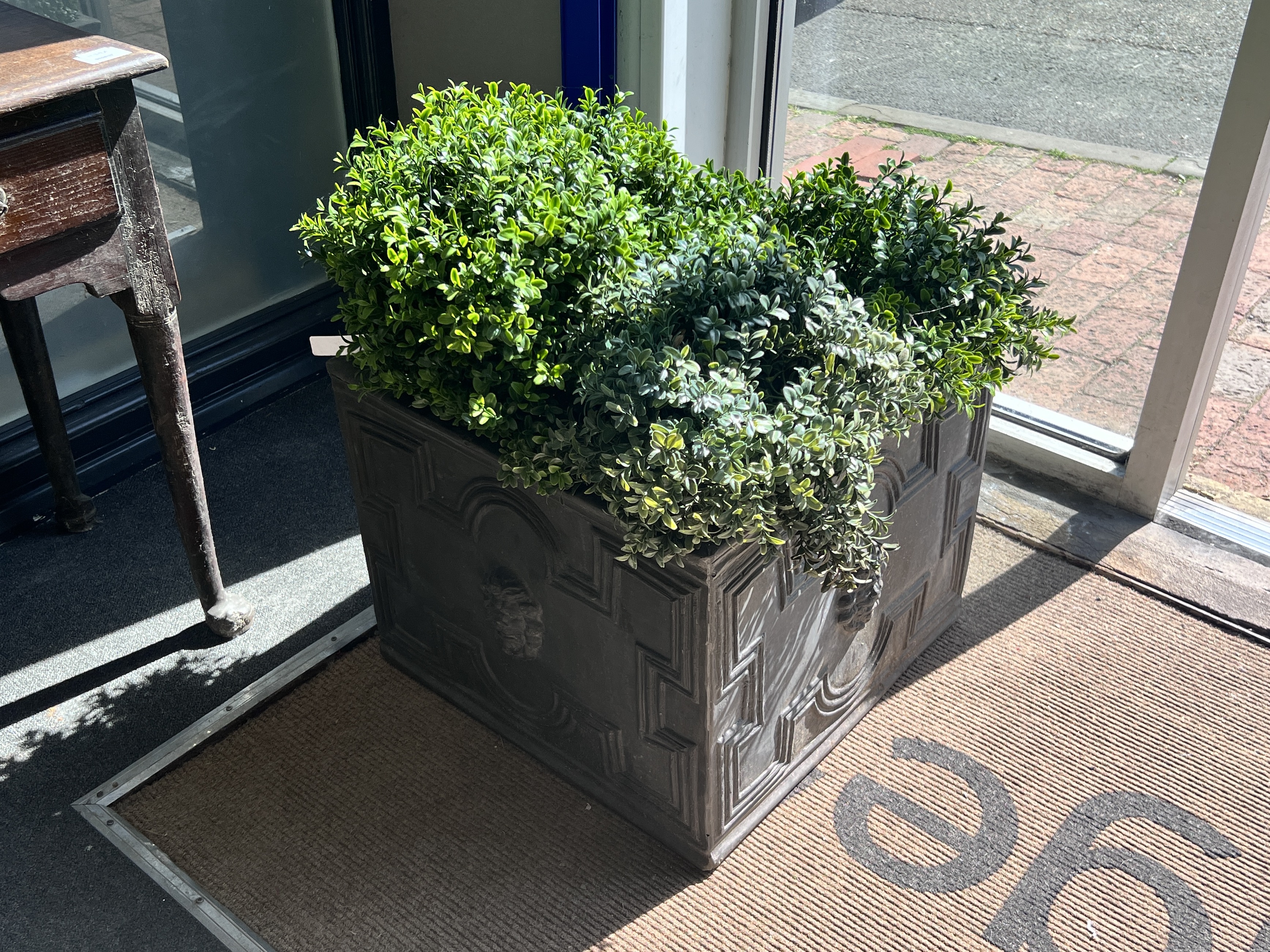 A pair of square faux lead square planters with faux box balls, width 50cm, height 40cm